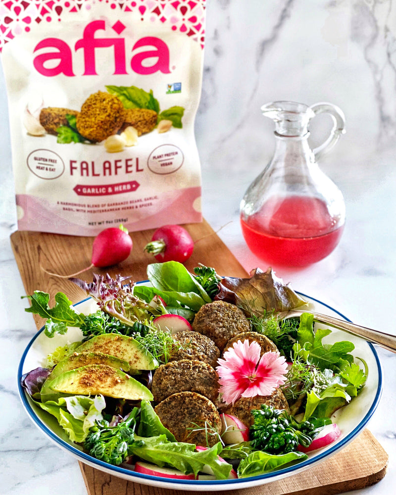Spring salad with Afia Garlic & Herb Falafel in a bowl.