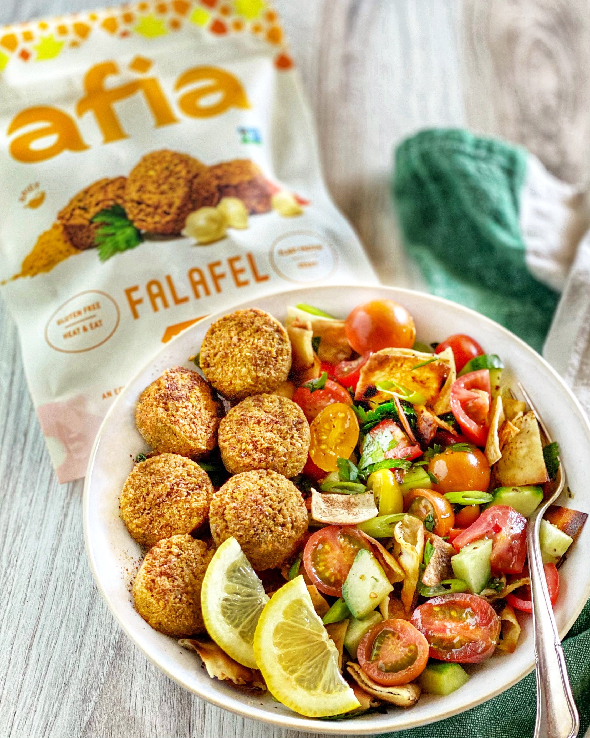 Fattoush in a bowl topped with Afia Falafel. 