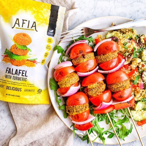 Platter with kebabs, fresh vegetables, and Afia Falafel
