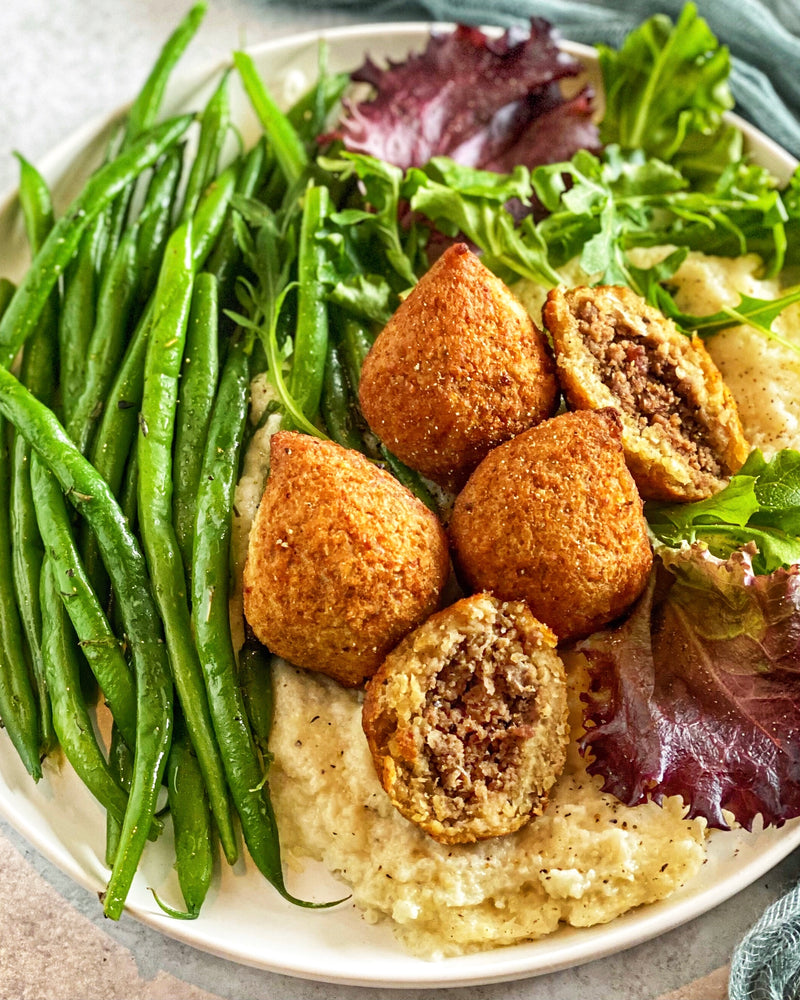 Afia Kibbeh with green beans and mashed cauliflower on a plate