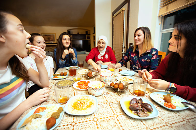 Group of women around a table sharing a meal.