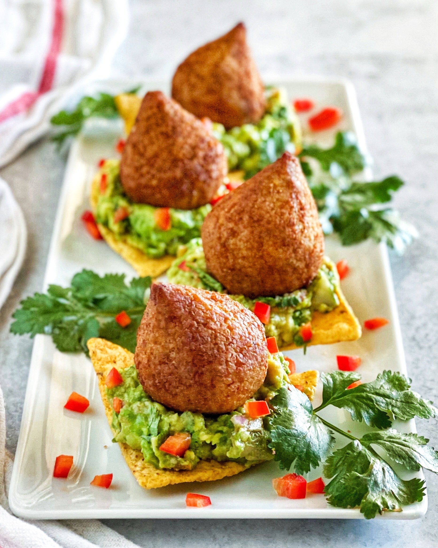 Fusion nachos on a platter topped with Afia Kibbeh. 