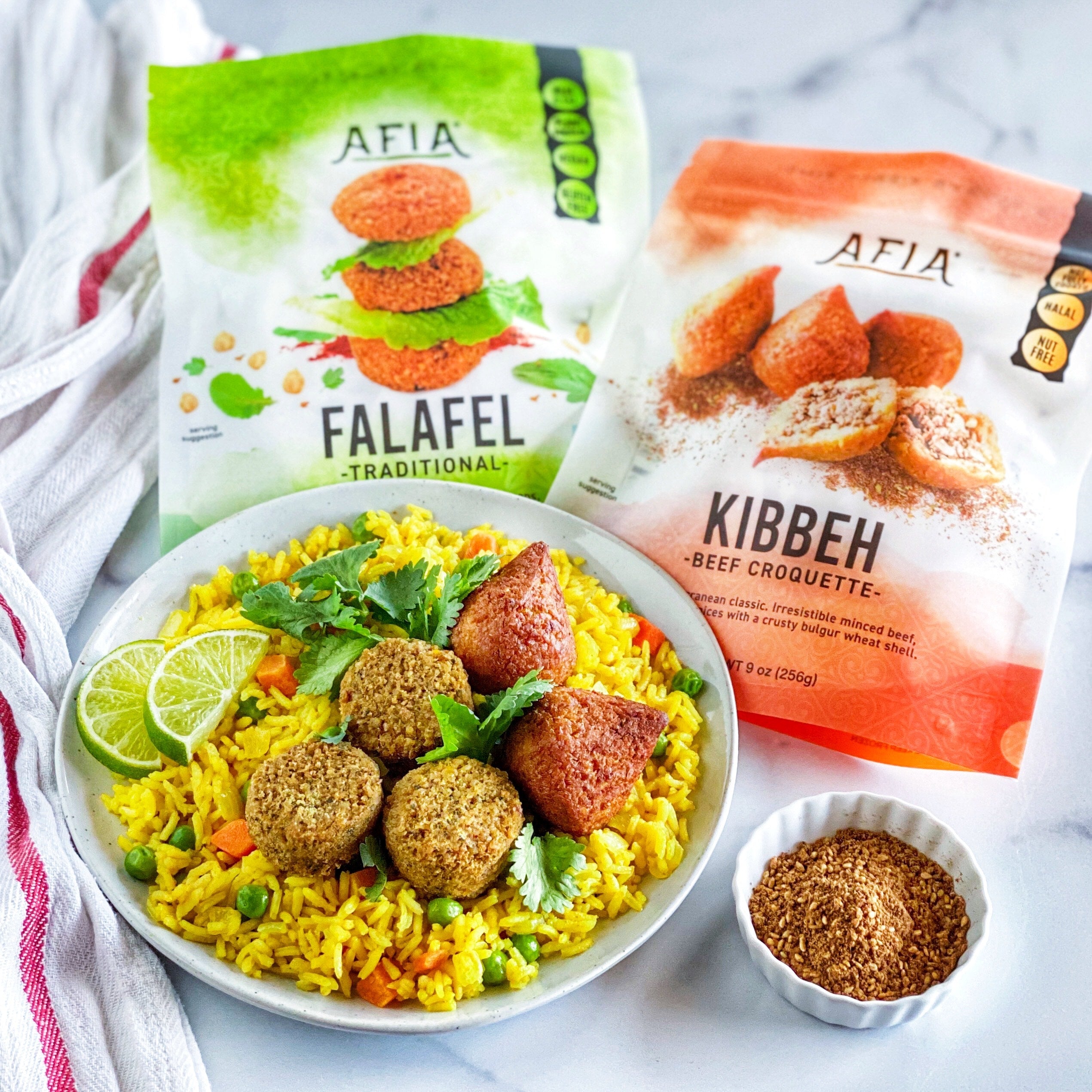 Turmeric coconut rice topped with Afia Falafel or Kibbeh.