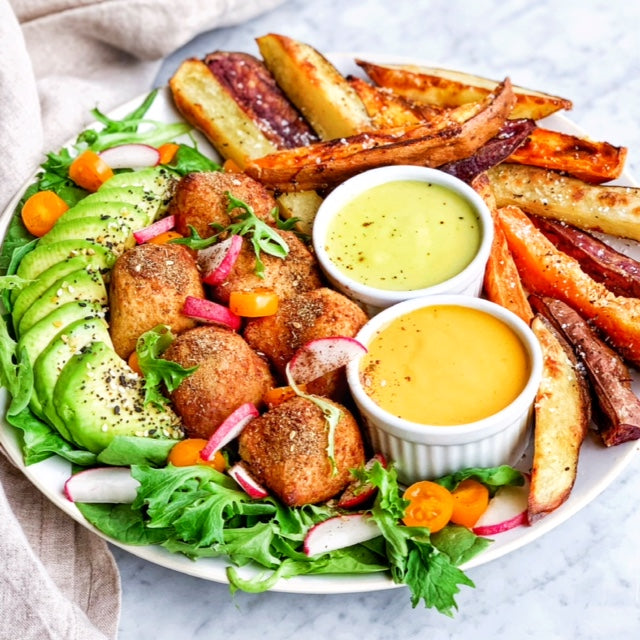 Platter with sauces, oven baked potatoes, garnishing, and Afia Kibbeh.