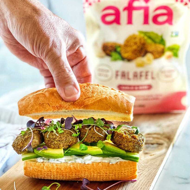 Sub sandwich with avocado, sprouts, dip, and Afia Garlic and Herb Falafel. 