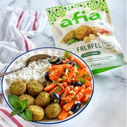 Rice bowl with carrots and olives topped with Afia Traditional Falafel. 